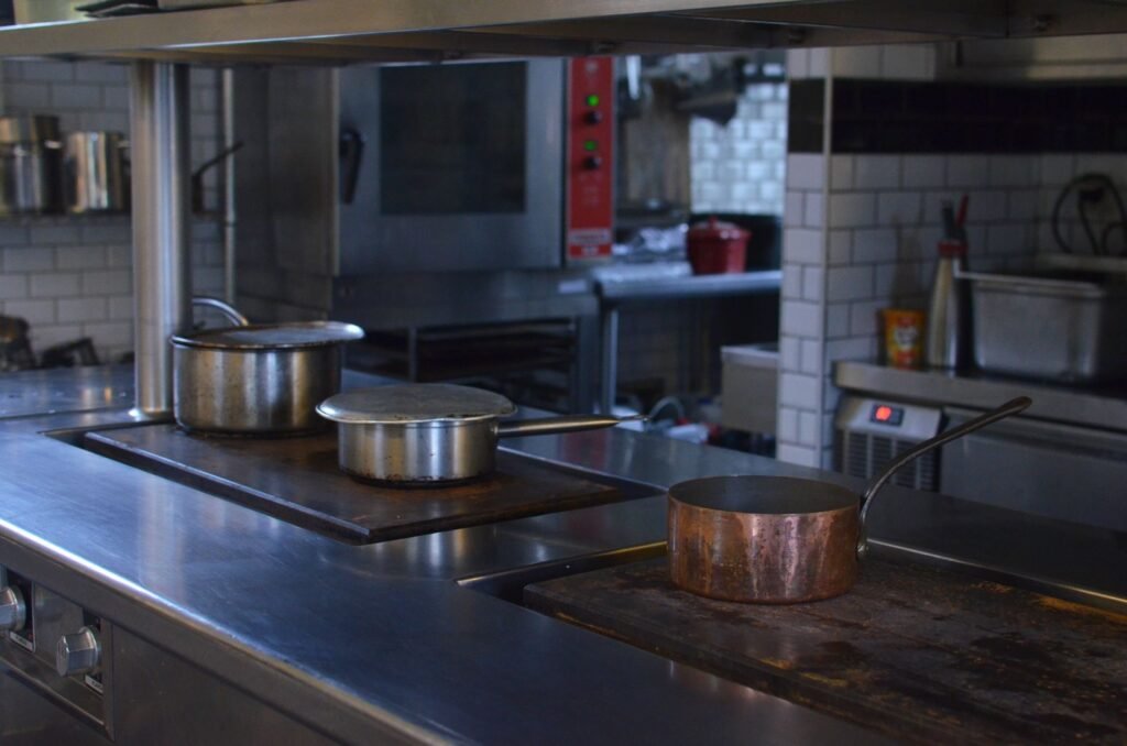 Cocina profesional de restaurante con ollas de acero inoxidable, escenario de uno de los casos de uso de IA en empresas