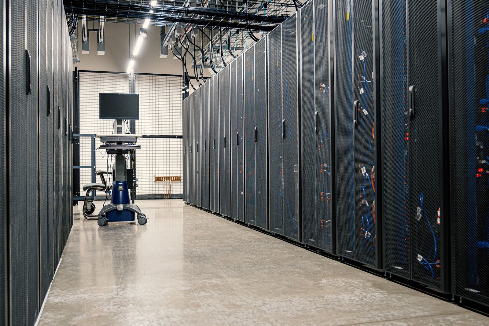 Pasillo de un centro de datos con filas de racks de servidores, como los centros de datos de IA